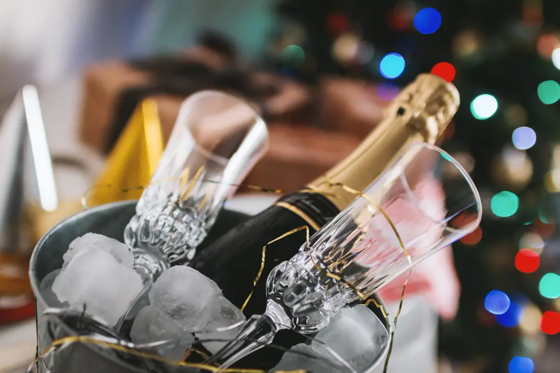 Cubeta con hielo, una botella y copas en una celebración