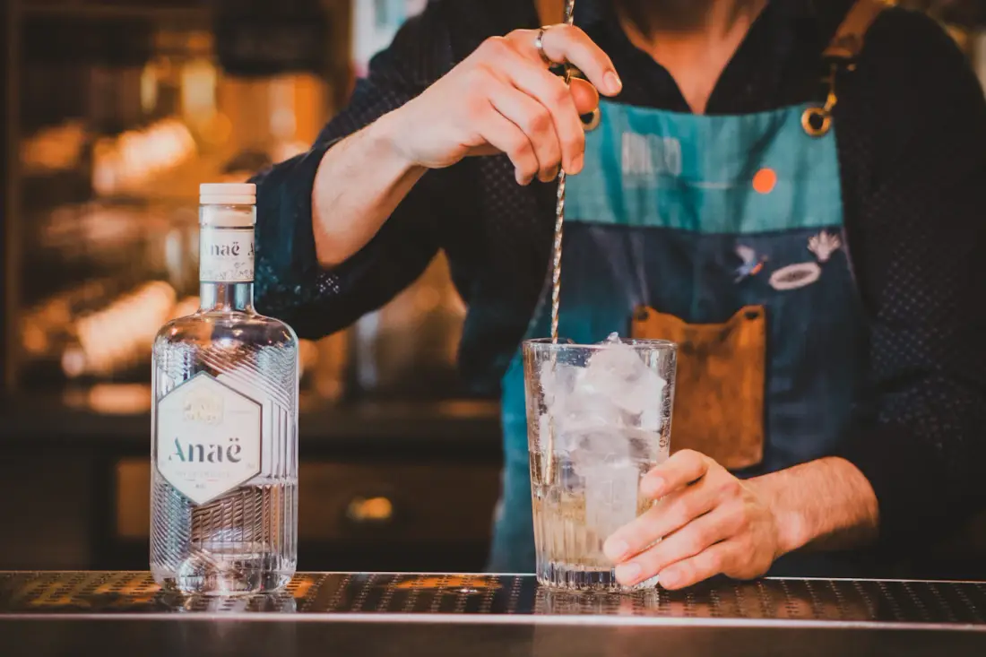 Bartender preparando una bebida en un vaso lleno de hielo